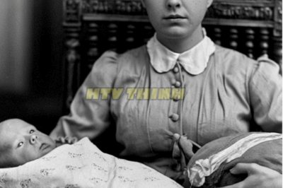In 1906, a mother holds her baby—until everyone freezes when they see what she is holding