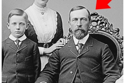 Why were historians pale when enlarging this 1901 family studio photo? Dr.Elizabeth Carter scrolled through another batch of digitized photographs on her computer screen.  The November afternoon felt quiet in the University of Pennsylvania archives office, the only sound, the gentle hum of her computer.  As a historian specializing in early 20th century immigration, she had examined thousands of similar images, formal studio portraits of immigrant families, carefully posed and stiffly dignified.  This particular collection came from a Philadelphia photography studio that had operated from 1887 until 2003.  The owners had preserved decades of glass plate negatives, and Elizabeth’s team was digitizing them for a project documenting the city’s German immigrant community.  The photograph on her screen seemed unremarkable.  Dated March 1901, it showed a family of five in typical formal arrangement.  A stern father seated in an ornate chair, his wife standing beside him with her hand on his shoulder, three children arranged around them.  The father wore a dark suit with a high starched collar.