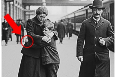 Why were historians speechless when they enlarged this portrait of a mother and her son from 1900? In the summer of 2018, Dr.Rebecca Torres sat in the dimly lit archives of Harvard University’s Widner Library, surrounded by boxes of deteriorating photographs from the turn of the century.  As a historian specializing in immigration and labor movements in early 20th century America, she had spent countless hours examining images of working-class families, hoping to piece together the untold stories of those who built the nation from the shadows.  The air smelled of old paper and preservation chemicals, a scent she had grown to associate with discovery.  That afternoon, Rebecca carefully lifted a fragile photograph from a Manila envelope marked Boston Railway Station collection, 1900, 1905.  The image showed a woman in a dark worn dress embracing a young boy, perhaps 8 years old, on what appeared to be a train platform.  The woman’s face was turned downward, her expression hidden, but her posture conveyed unmistakable sorrow.  The boy stared directly at the camera with hollow, tired eyes that seemed far too old for his small frame. 👉 Click the link below to read the full story…