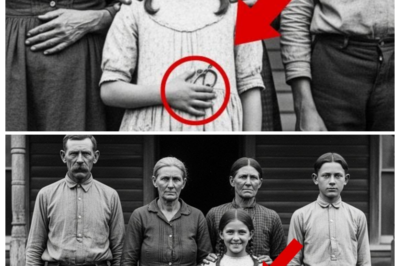 A Girl Smiles in 1895 — But Her Clenched Fist Holds a Hidden Truth     Dr.Sarah Mitchell adjusted her glasses as the afternoon light filtered through the tall archive windows in Louisville.  The Kentucky Historical Society had just acquired a collection of Dgerara types from an estate sale in Harlem County, and Sarah had volunteered to catalog them.  It was tedious work, but she loved it.  The quiet intimacy of examining faces from another century, imagining their lives, their joys, their sorrows.  Most of the photographs were typical for the era.  Stiff families in their Sunday best, stern patriarchs with thick mustaches, holloweyed women who’d borne too many children, boys and girls forced to hold perfectly still for long exposures, their expressions frozen somewhere between boredom and terror.  Then she saw it.  The photograph was dated March 1895, taken in front of a modest wooden house with a sagging porch and narrow windows.  A family of four stood in a neat line.  A broad-shouldered man with a thick mustache and cold eyes.